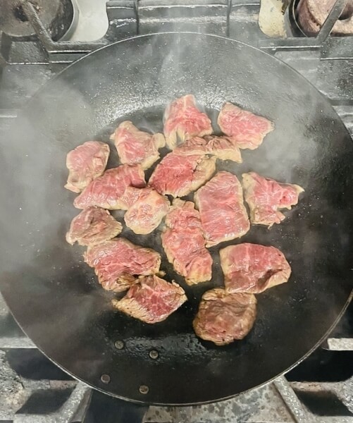 鉄フライパンで牛肉を焼いている様子