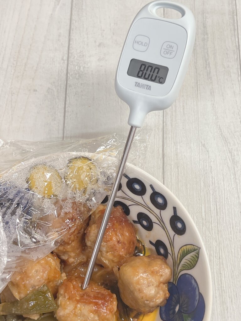 冷凍ミートボールを電子レンジで加熱後、中心温度を温度計で測っている様子