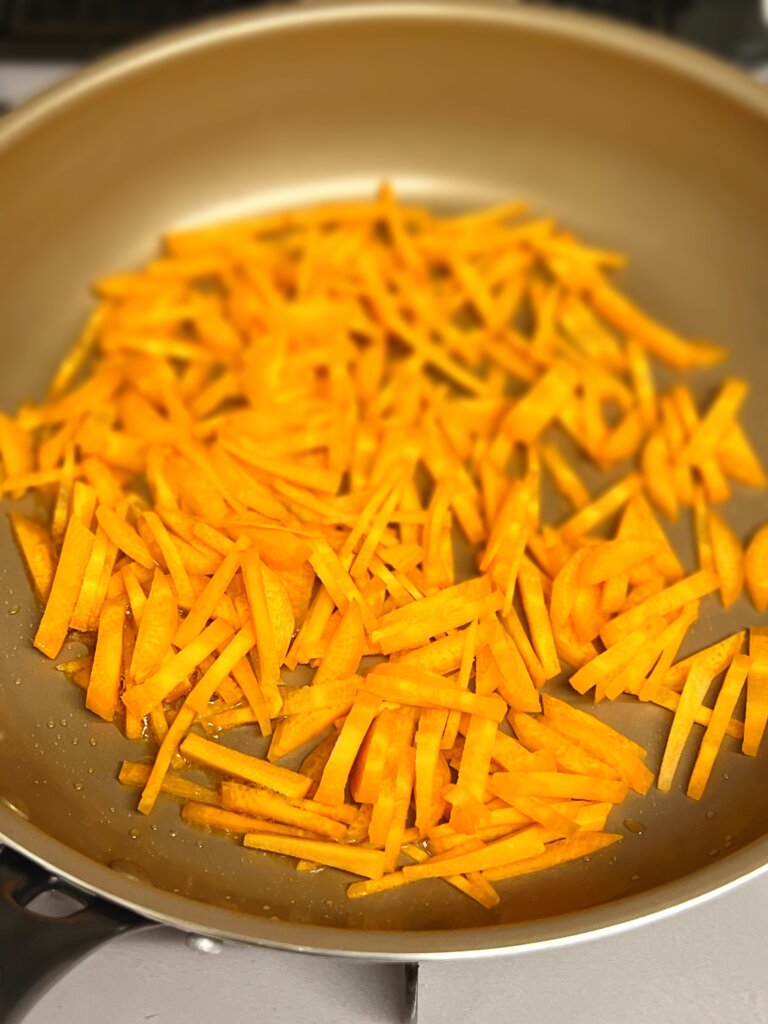 にんじんをフライパンで炒めるところ