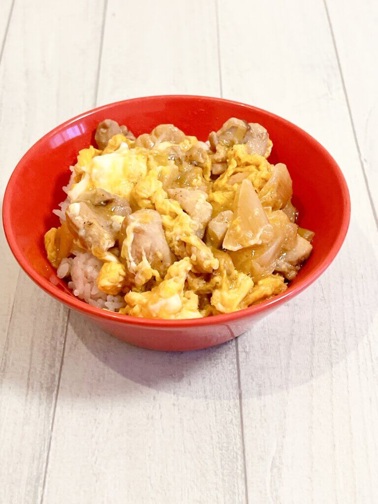 親子丼の具を真空冷凍して温め、卵でとじた完成写真。赤いボウルに盛り付けた親子丼。