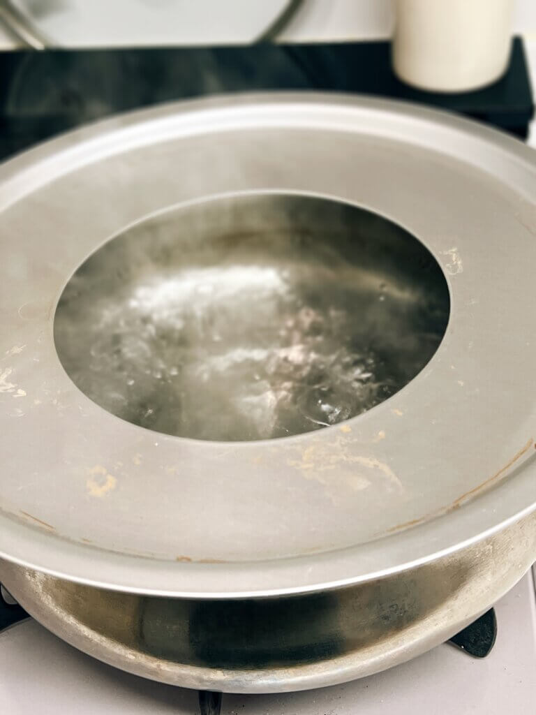 蒸し板を使って鍋にせいろをセットしている様子