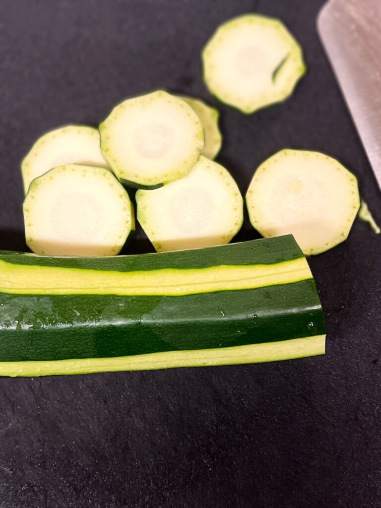 ズッキーニを包丁で輪切りにしている