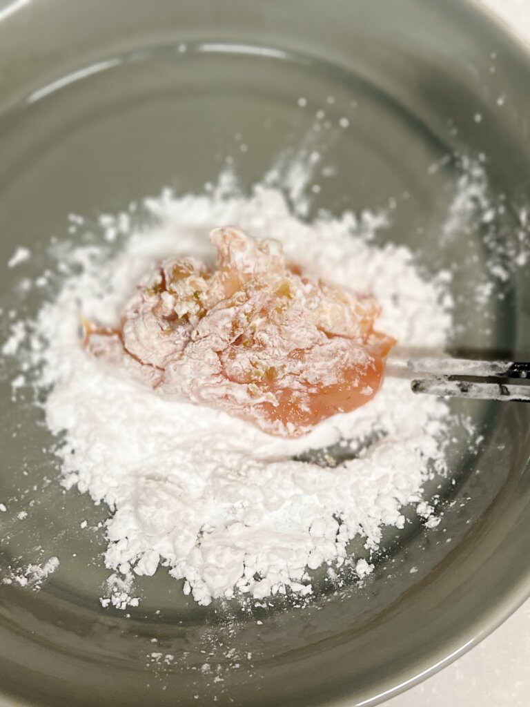 下味をつけた鶏もも肉に片栗粉をまぶす工程